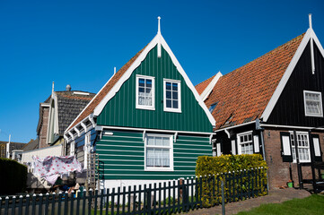 Walking on sunny day in small Dutch town Marken with wooden houses located on former island in North Holland, Netherlands