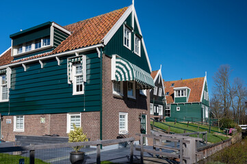 Walking on sunny day in small Dutch town Marken with wooden houses located on former island in North Holland, Netherlands