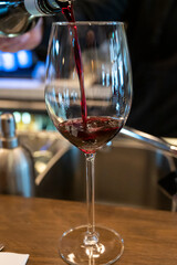 Pouring of dry Spanish tempranillo red wine in glass in Spanish bogeda restaurant