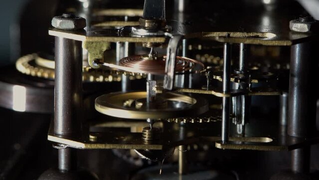 Macro video of the primitive clockwork mechanism of an old desktop alarm clock