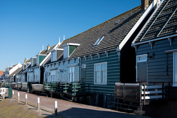 Fototapeta premium Walking on sunny day in small Dutch town Marken with wooden houses located on former island in North Holland, Netherlands