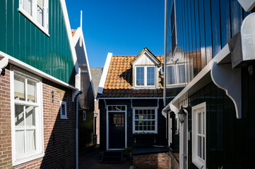 Walking on sunny day in small Dutch town Marken with wooden houses located on former island in North Holland, Netherlands