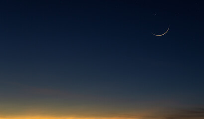 Naklejka na ściany i meble Crescent moon on dusk sky twilight after sundown symbol of religion islamic in Ramadan Kareem month space for text Eid al Adha, Eid Al Fitr