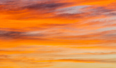 Golden sky with orange sunlight clouds in the evening on gold hour sky background 
