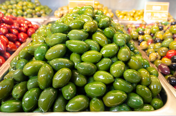 Green fresh olives close up on market, food background