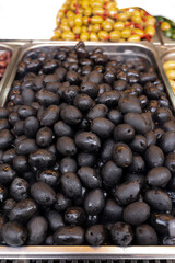 Black olives close up on market, food background
