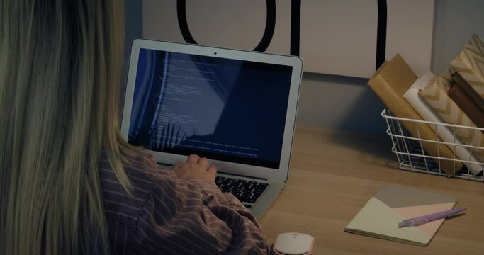 Female programmer working on laptop at table