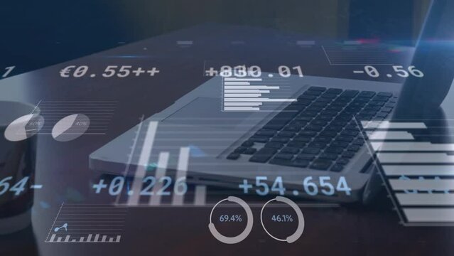 Animation of financial data and graphs moving over laptop lying on desk