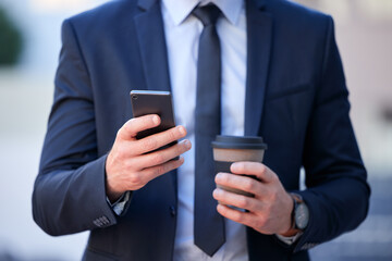 Thanks to technology, youre never far from the office. Cropped shot of an unrecognizable businessman texting while standing outside in the city.