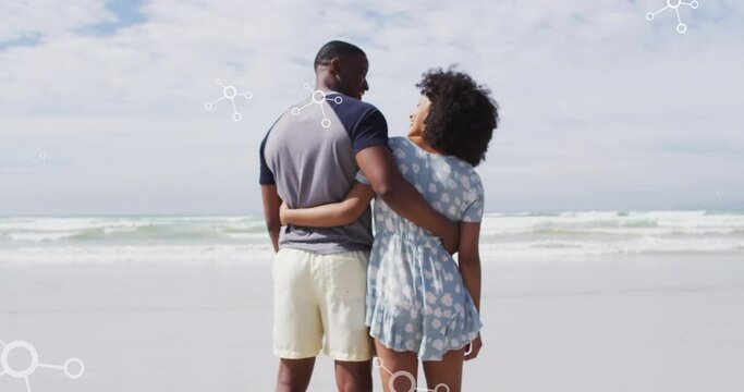 Animation of molecules over back view of african american couple embracing at beach