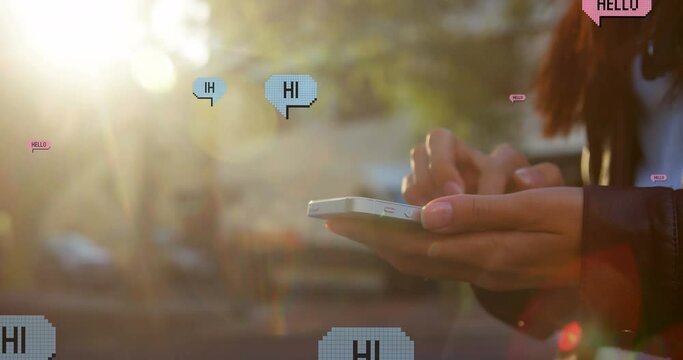Animation of hello and hi over hands of biracial woman using smartphone in city