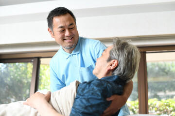 高齢者をベッドで介助する男性介護士
