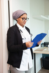 physician looks at a clipboard