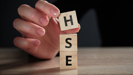 Acronym HSE or Health Safety Environment. Person makes a word from cubes