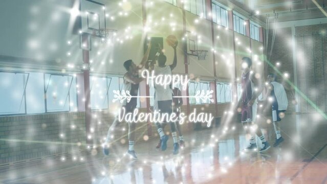 Animation of happy valentine's day text and spots over diverse group of basketball players at gym