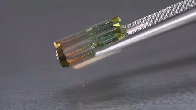 natural bi-color polychromatic tourmaline octagon cut in the tweezers