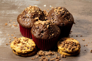 Baked bread known as chocolate muffins(cupcakes) served with chocolate chip cookies