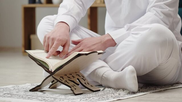 Middle Eastern man praying close-up, islamic religion. Religious holiday Ramadan, holy month. Worship, making traditional prayer to God, reading quran. 