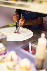Working his food magic. Shot of an unidentifiable food vendor preparing a sweet treat at a market stall.