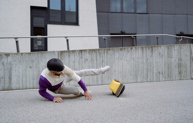 Selective focus caucasian man fallen on the asphalt ground while driving at electronic board