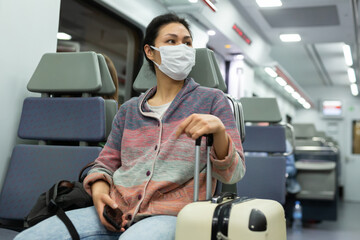 Asian woman in protective mask sitting in subway train