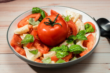 An Italian caprese salad of mozzarella, tomato and basil with olive oil and vinegar.