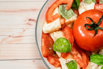 Close up of Classic Italian caprese salad of mozzarella, tomato and basil with olive oil and vinegar.