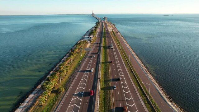 Road to Sunshine Skyway Bridge spanning the Lower Tampa Bay and connecting Terra Ceia to St. Petersburg, Florida, USA. Day video. Ocean or Gulf of Mexico seascape. Reinforced concrete bridge structure