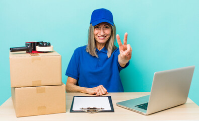 senior gray hair woman smiling and looking friendly, showing number two. employee packer concept