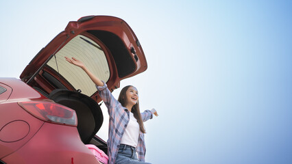 Beautiful Asian woman is sitting in the back of a sedan. showing arms up smiling happily.Cute woman...