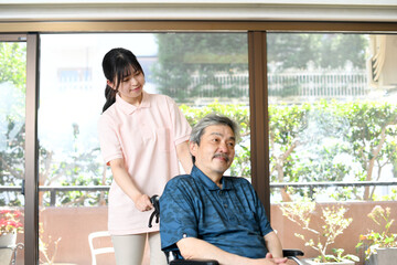 高齢者と車椅子を押す女性介護士