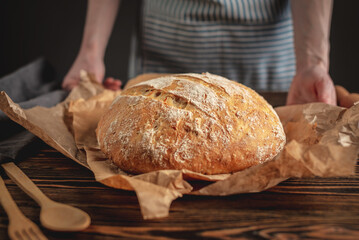 Homemade natural fresh bread with a Golden crust on a napkin on an old wooden background. Baking bakery products