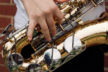 hands of a person playing the saxophone