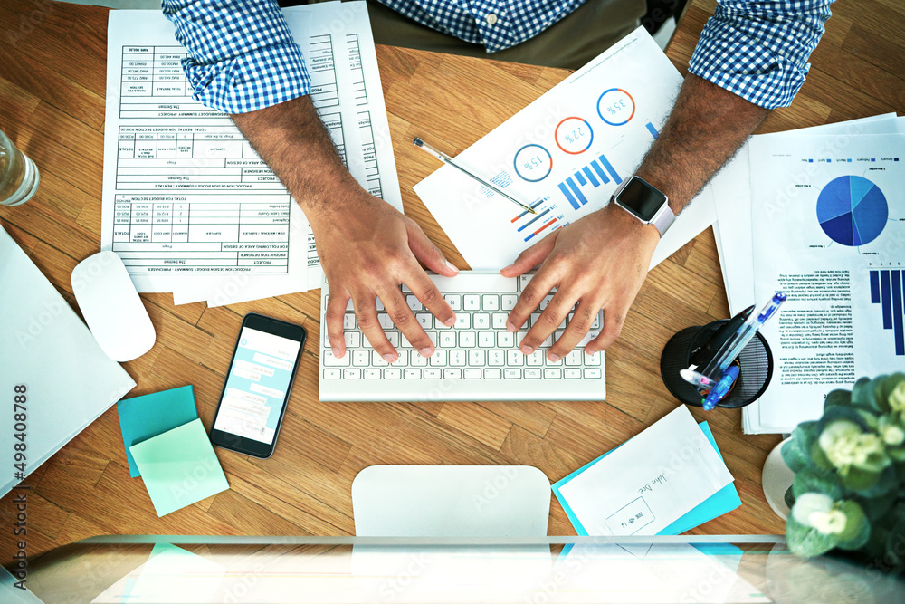 Poster his hands are magic on a keyboard. high angle shot of an unrecognizable businessman working in his o