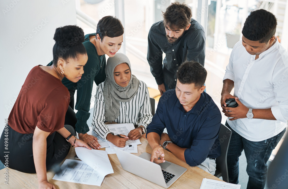 Aufkleber tasks are completed quicker thanks to teamwork. shot of a group of businesspeople using a laptop dur