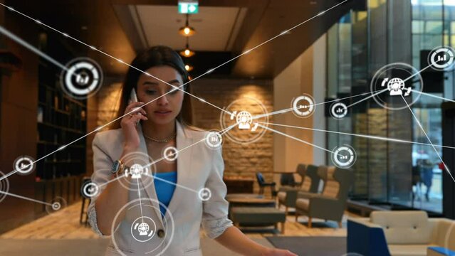 Animation of network of connections with icons over biracial businesswoman talking on smartphone