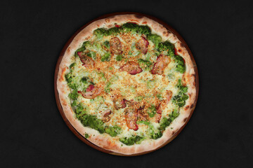 Bacon broccoli pizza isolated on black background with wooden board