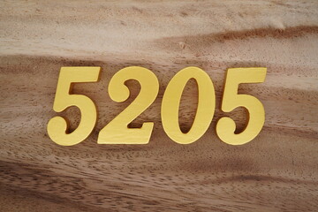 Golden Arabic numerals on a real brown and white wooden floor number 5205