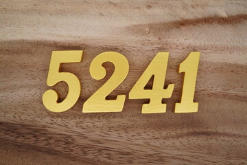 Golden Arabic numerals on a real brown and white wooden floor number 5241