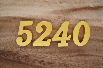 Golden Arabic numerals on a real brown and white wooden floor number 5240