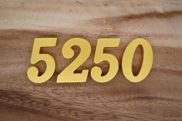 Golden Arabic numerals on a real brown and white wooden floor number 5250
