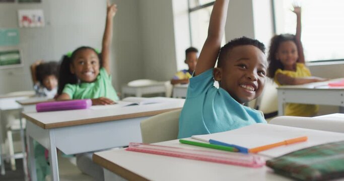 Video of happy african american boy raising hand during lesson