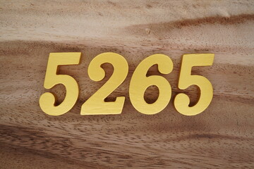 Golden Arabic numerals on a real brown and white wooden floor number 5265