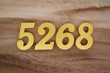 Golden Arabic numerals on a real brown and white wooden floor number 5268
