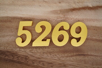Golden Arabic numerals on a real brown and white wooden floor number 5269