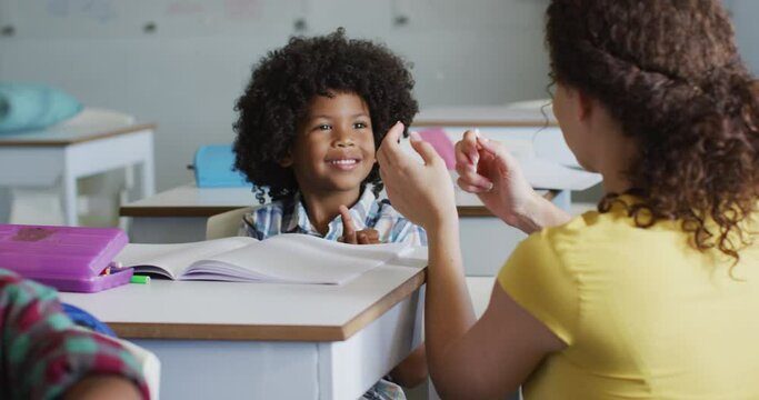 Video of happy caucasian female teacher learning math to african american boy