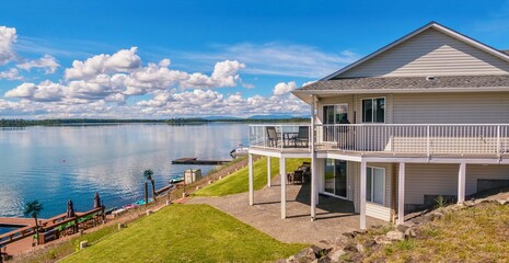 Wide angle view of a beautiful, large modern luxury summer holiday home, featuring sun decks, glass...