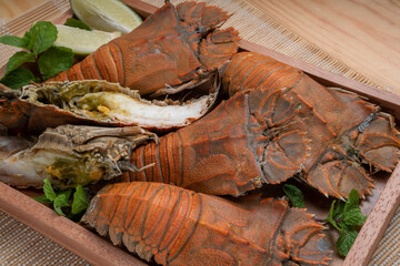 Flathead lobster on wooden background, Flathead lobster or Mantis shrimp on wooden plate ready to...
