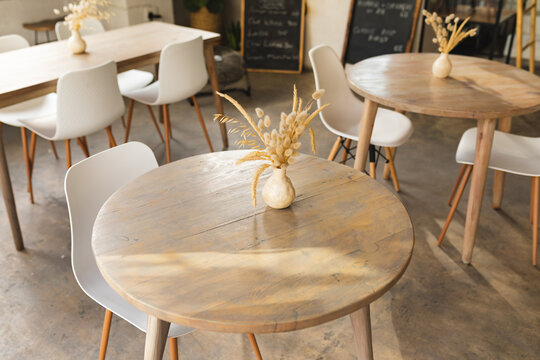 High Angle View Of Decor Vase On Wooden Table With Chair In Modern Coffee Shop