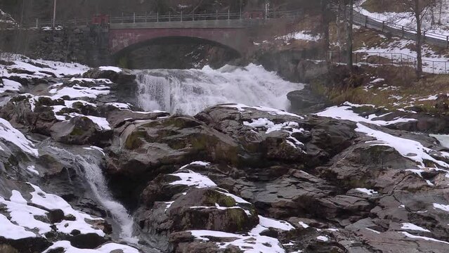 Slow motion waterfall passing under a brick bridge
